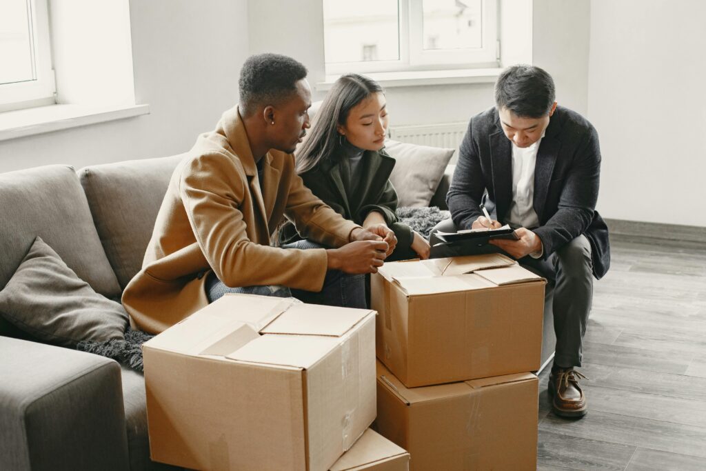 packing boxes in a room while a couple talking to a consultant