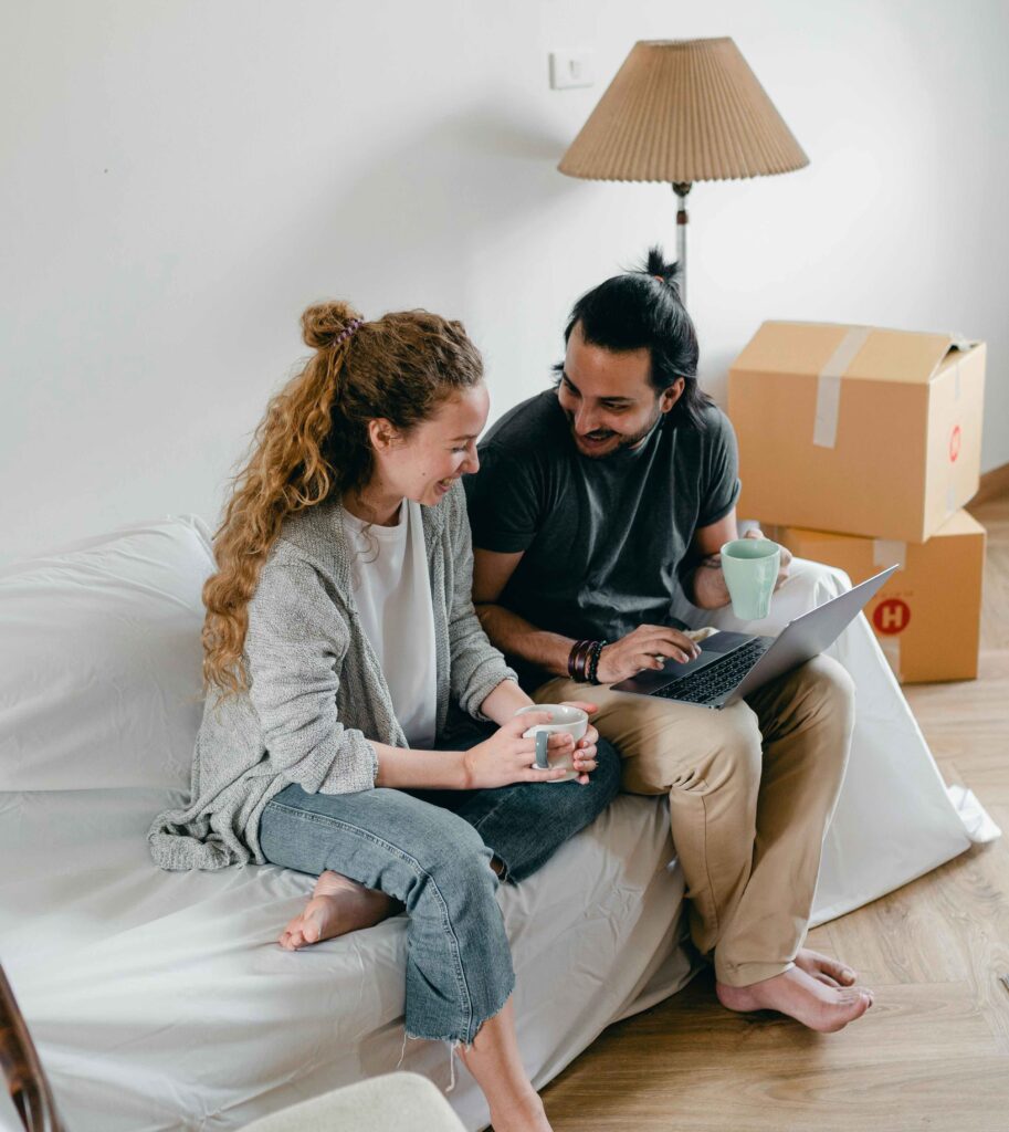 Couple sat on bed, with their laptop