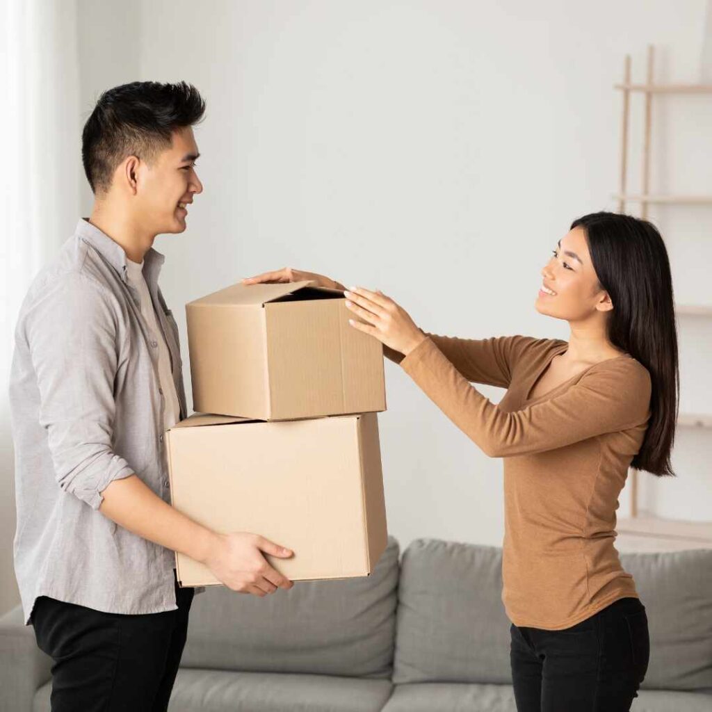 Woman and man in a room and the man is holding two cardboard boxes