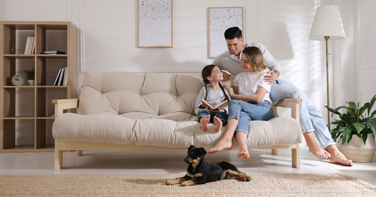 family sat on the sofa in their home smiling looking happy