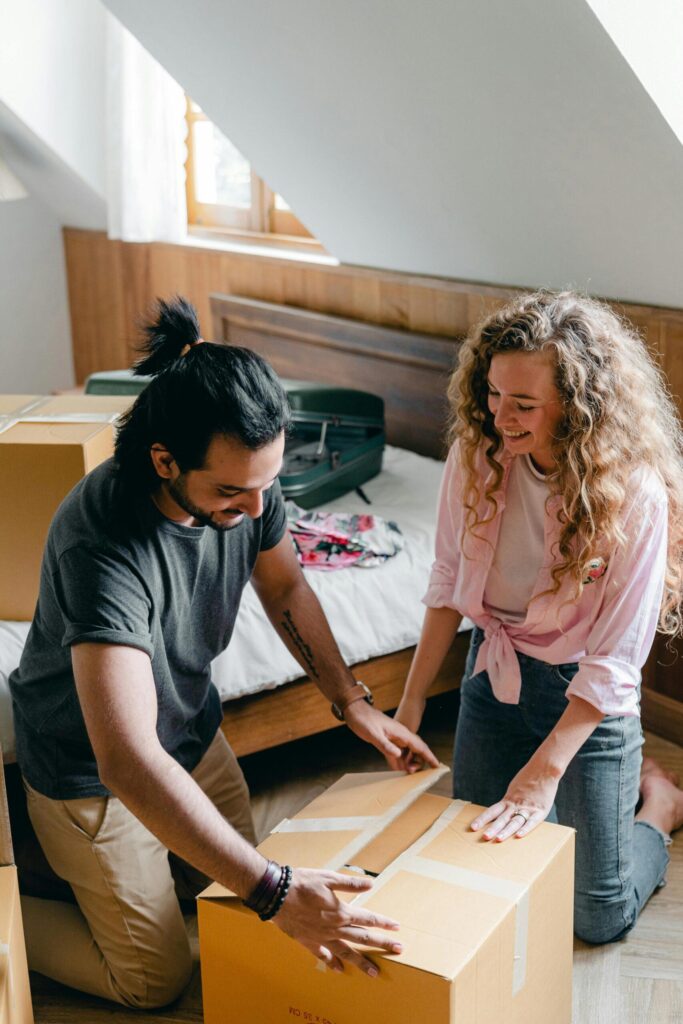 Couple excited opening a box in their new home, made stress free by Santa Fe Relocation.