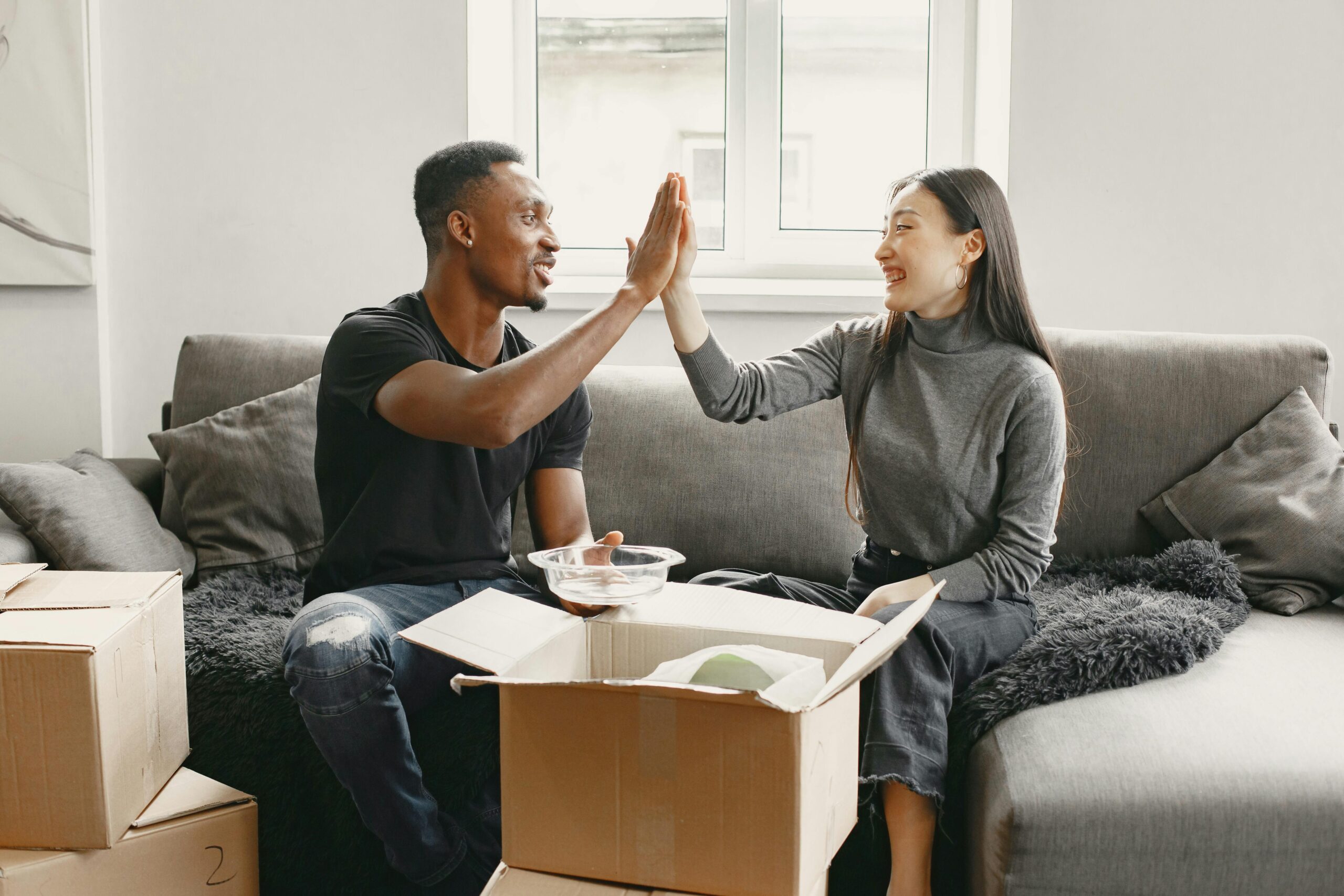 Couple giving a high five after booking with one of the top moving service in Singapore. Book your stress free international move with Santa Fe Relocation.