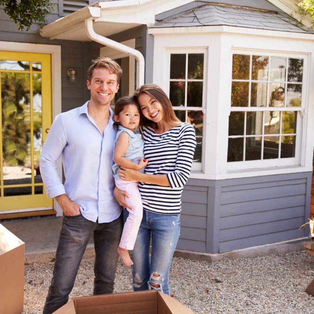 Couple and child outside their new house, happy to be settled in after a stress free move with Santa Fe Relocation.